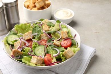 Photo of Delicious salad with croutons and vegetables served on light grey table, closeup. Space for text