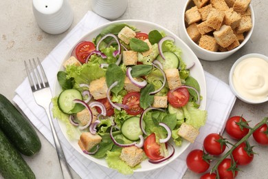 Photo of Delicious salad with croutons and vegetables served on light grey table, flat lay