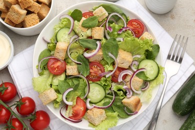 Photo of Delicious salad with croutons and vegetables served on light grey table, flat lay
