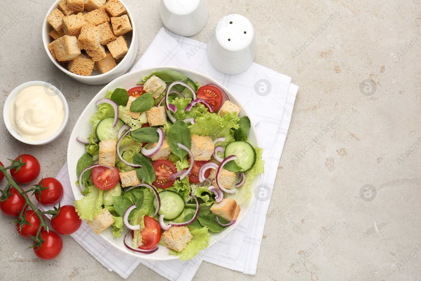 Photo of Delicious salad with croutons and vegetables served on light grey table, flat lay. Space for text