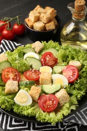 Photo of Delicious salad with croutons and ingredients on table, closeup
