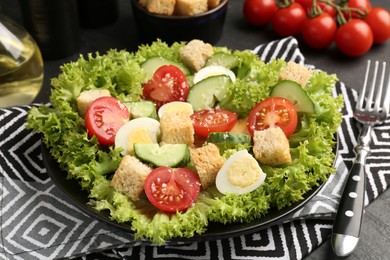 Photo of Delicious salad with croutons and ingredients on table, closeup