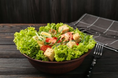 Photo of Delicious salad with croutons, chicken, egg, vegetables, lemon and arugula on wooden table, closeup