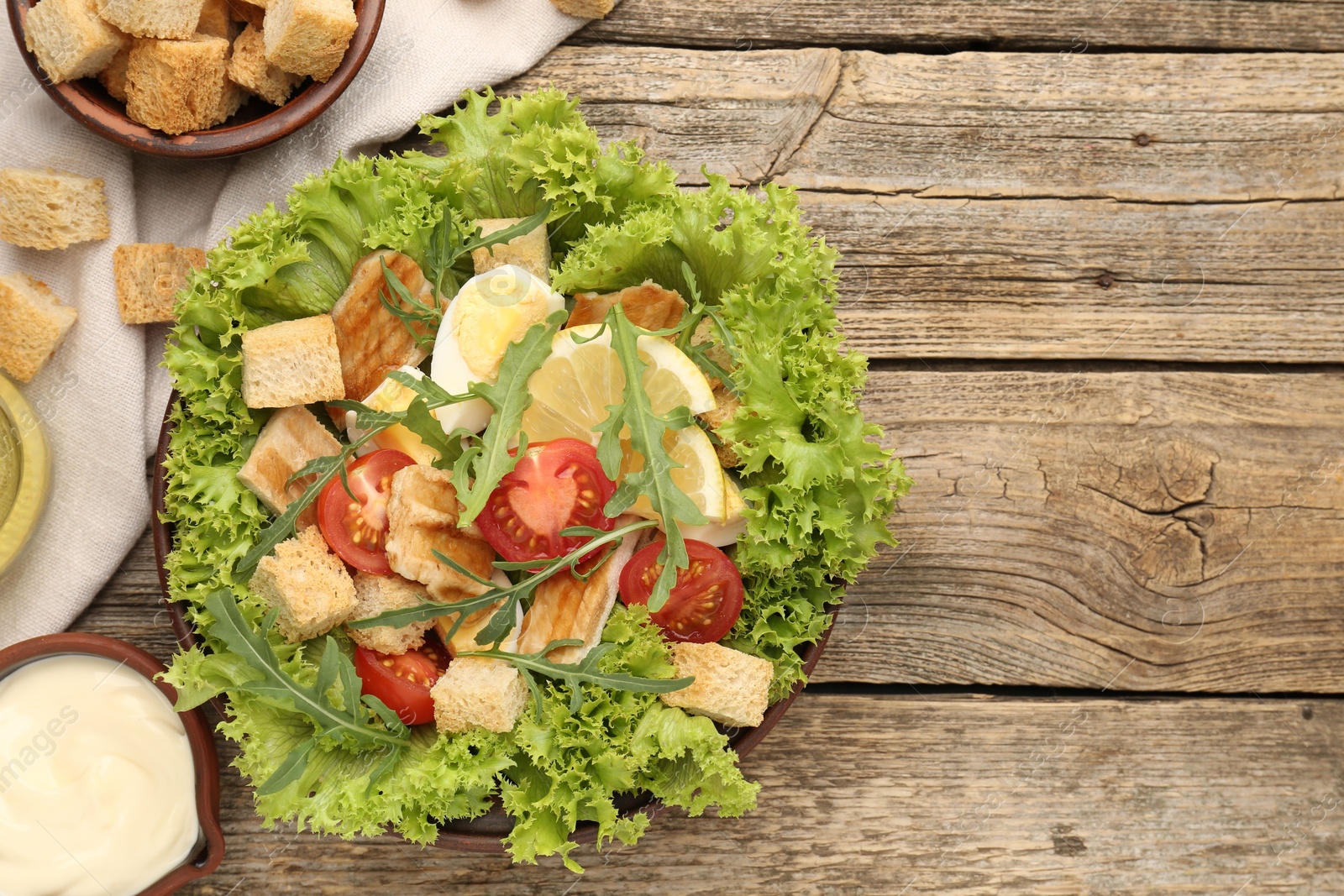 Photo of Delicious salad with croutons served on wooden table, flat lay. Space for text