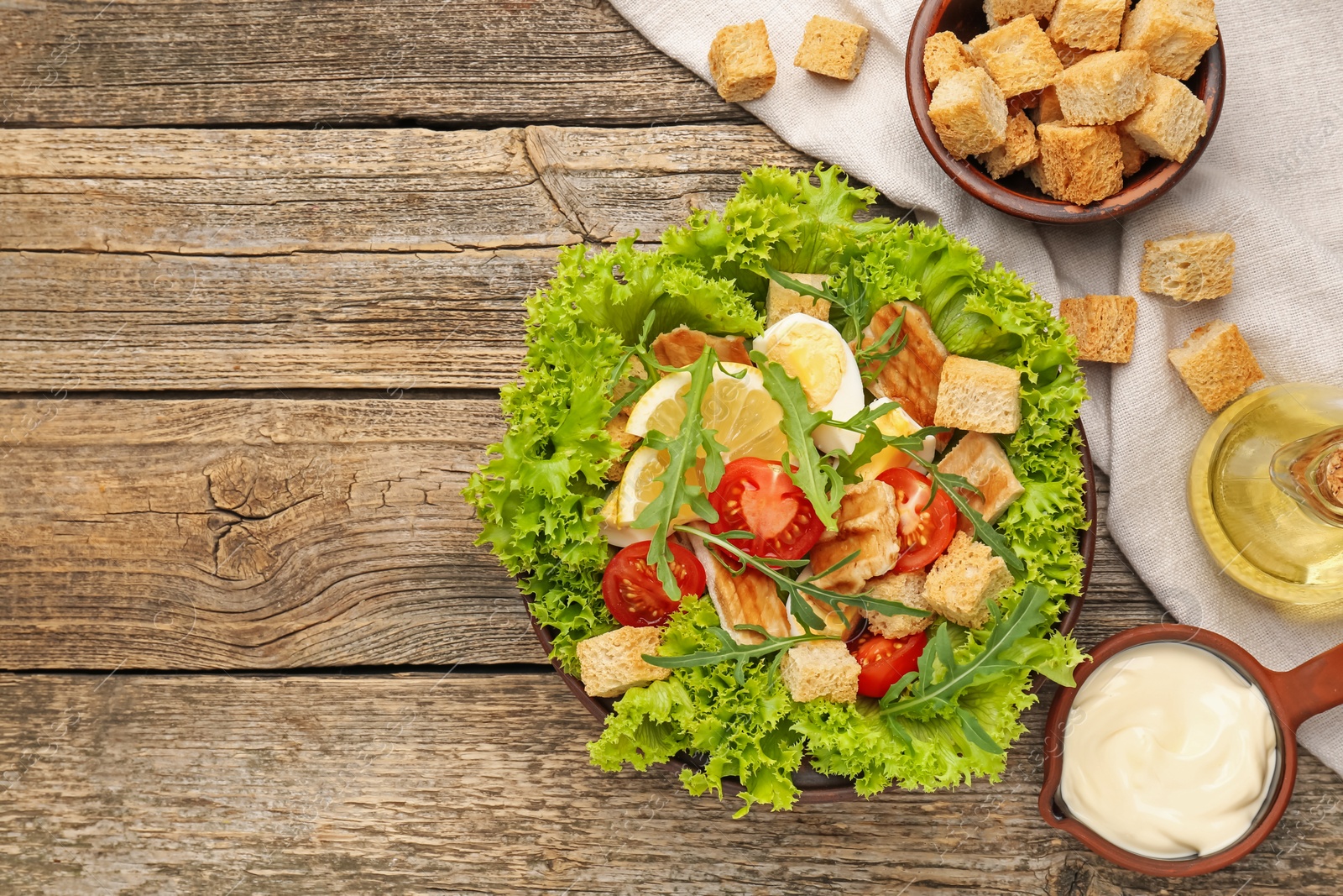 Photo of Delicious salad with croutons served on wooden table, flat lay. Space for text