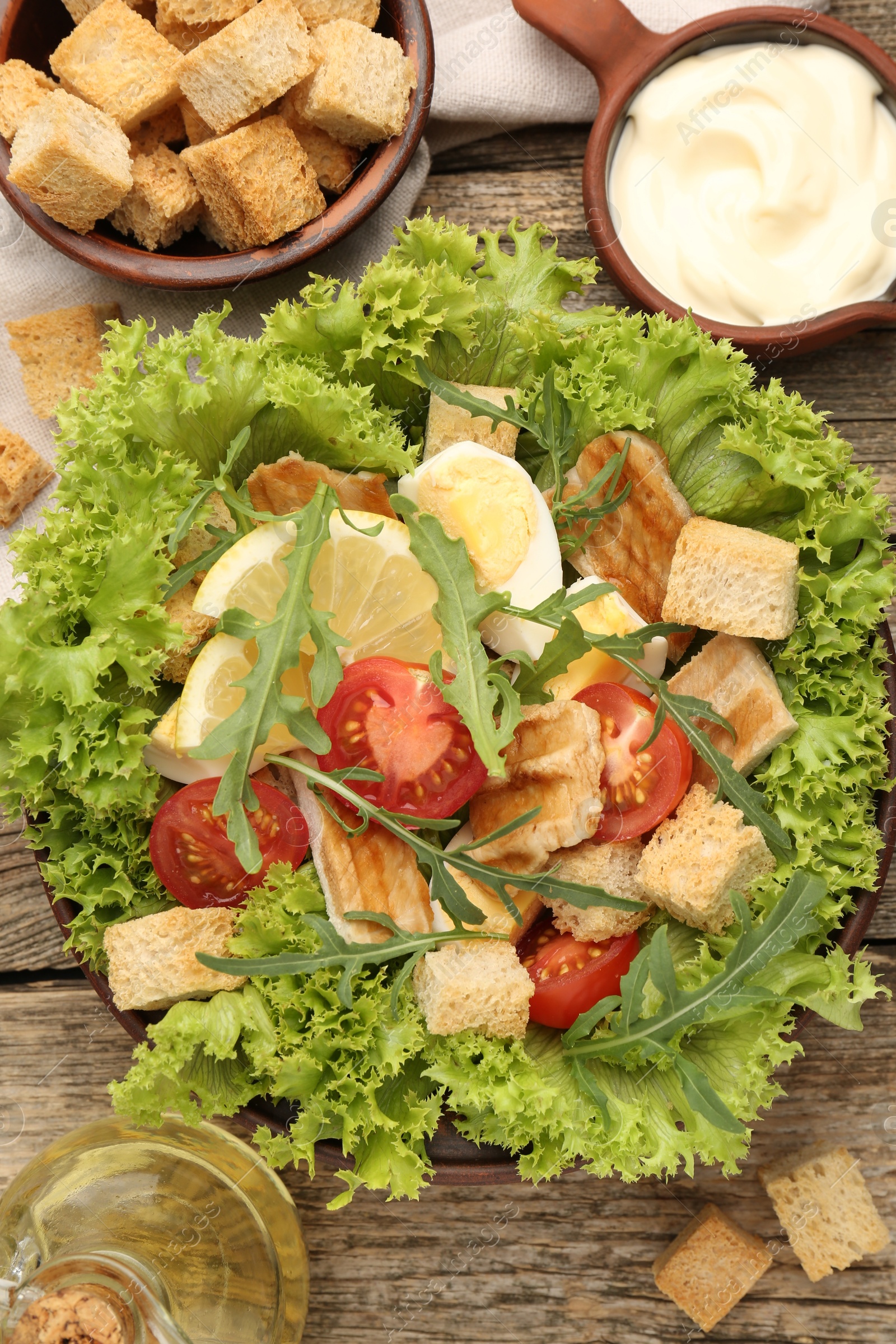 Photo of Delicious salad with croutons served on wooden table, flat lay