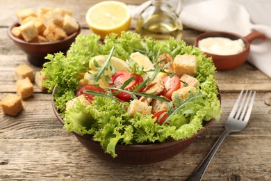 Photo of Delicious salad with croutons served on wooden table, closeup