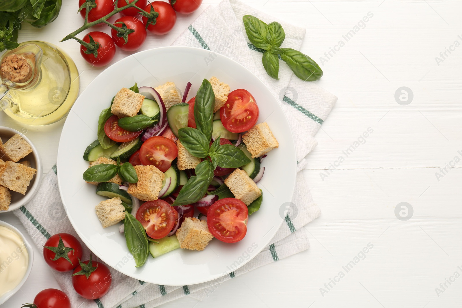Photo of Delicious salad with croutons and ingredients on white wooden table, flat lay. Space for text