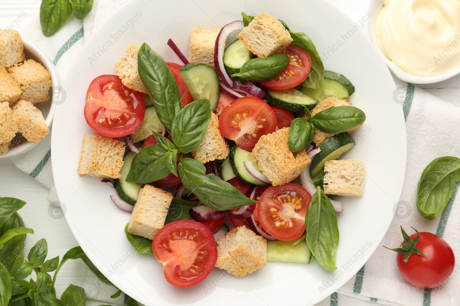 Photo of Delicious salad with croutons and ingredients on table, flat lay