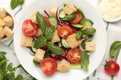 Photo of Delicious salad with croutons and ingredients on table, flat lay