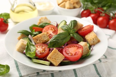 Photo of Delicious salad with croutons and ingredients on table, closeup
