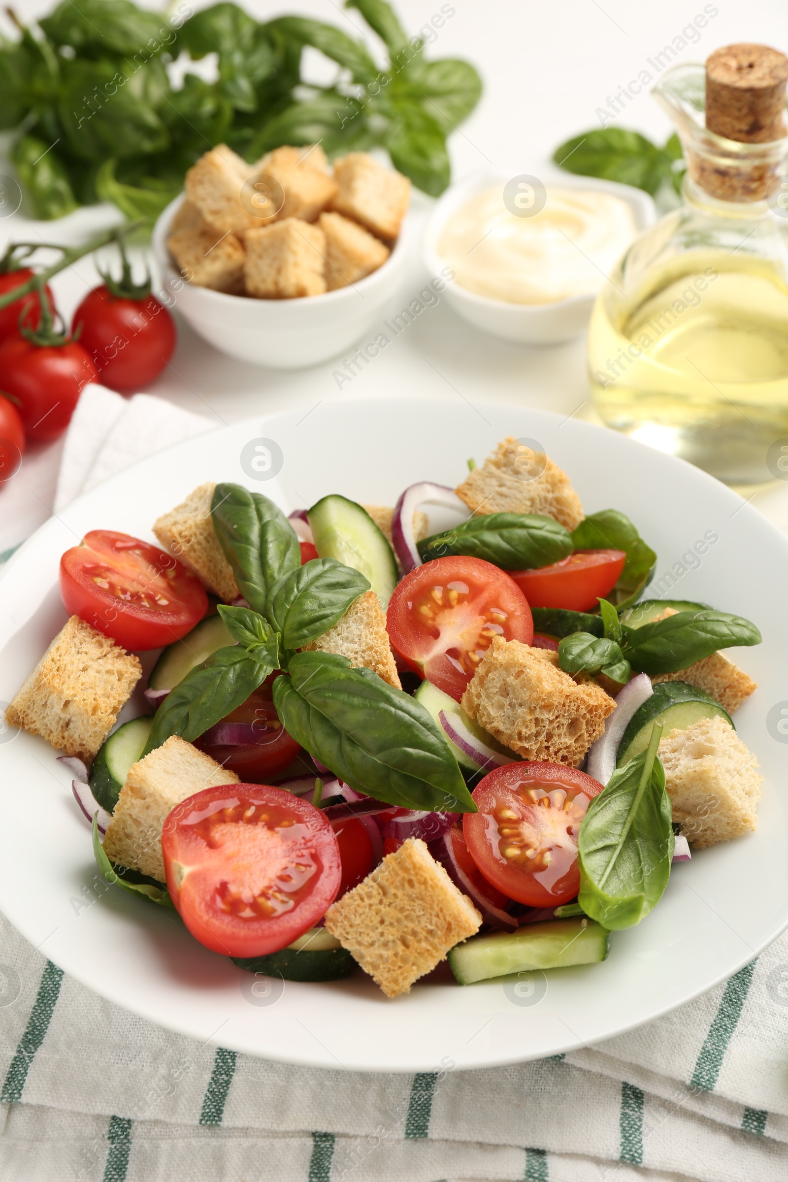 Photo of Delicious salad with croutons and ingredients on table, closeup