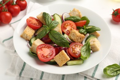 Photo of Delicious salad with croutons and ingredients on table, closeup