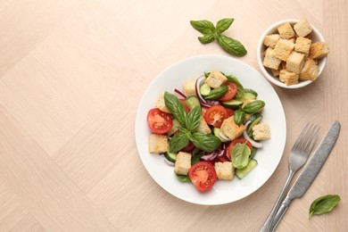 Photo of Delicious salad with croutons, vegetables and basil on wooden table, flat lay. Space for text