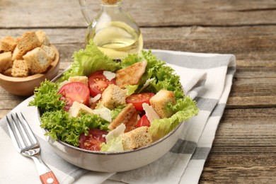 Photo of Delicious salad with croutons served on wooden table, closeup