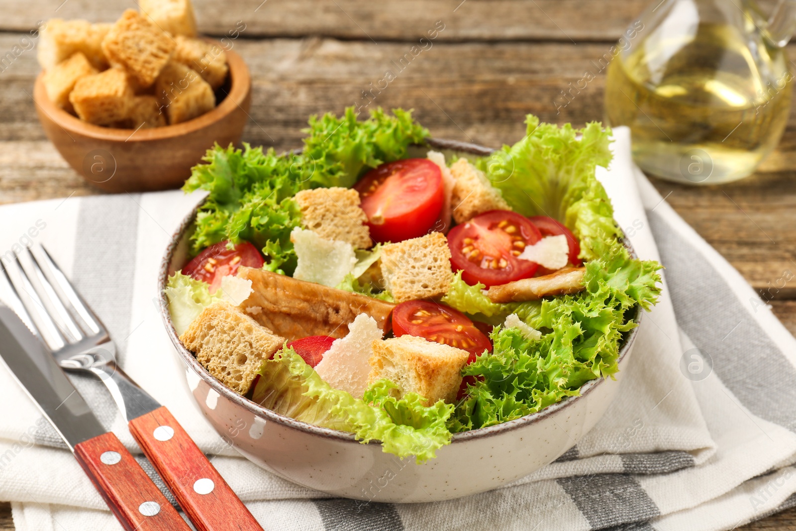 Photo of Delicious salad with croutons served on wooden table, closeup