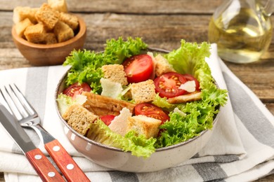 Photo of Delicious salad with croutons served on wooden table, closeup