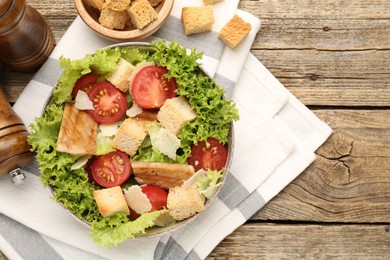 Photo of Delicious salad with croutons served on wooden table, flat lay. Space for text