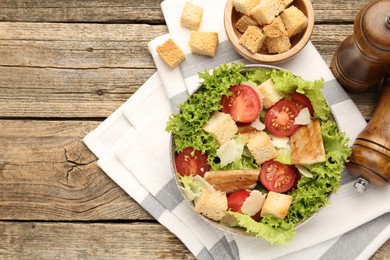 Photo of Delicious salad with croutons served on wooden table, flat lay. Space for text
