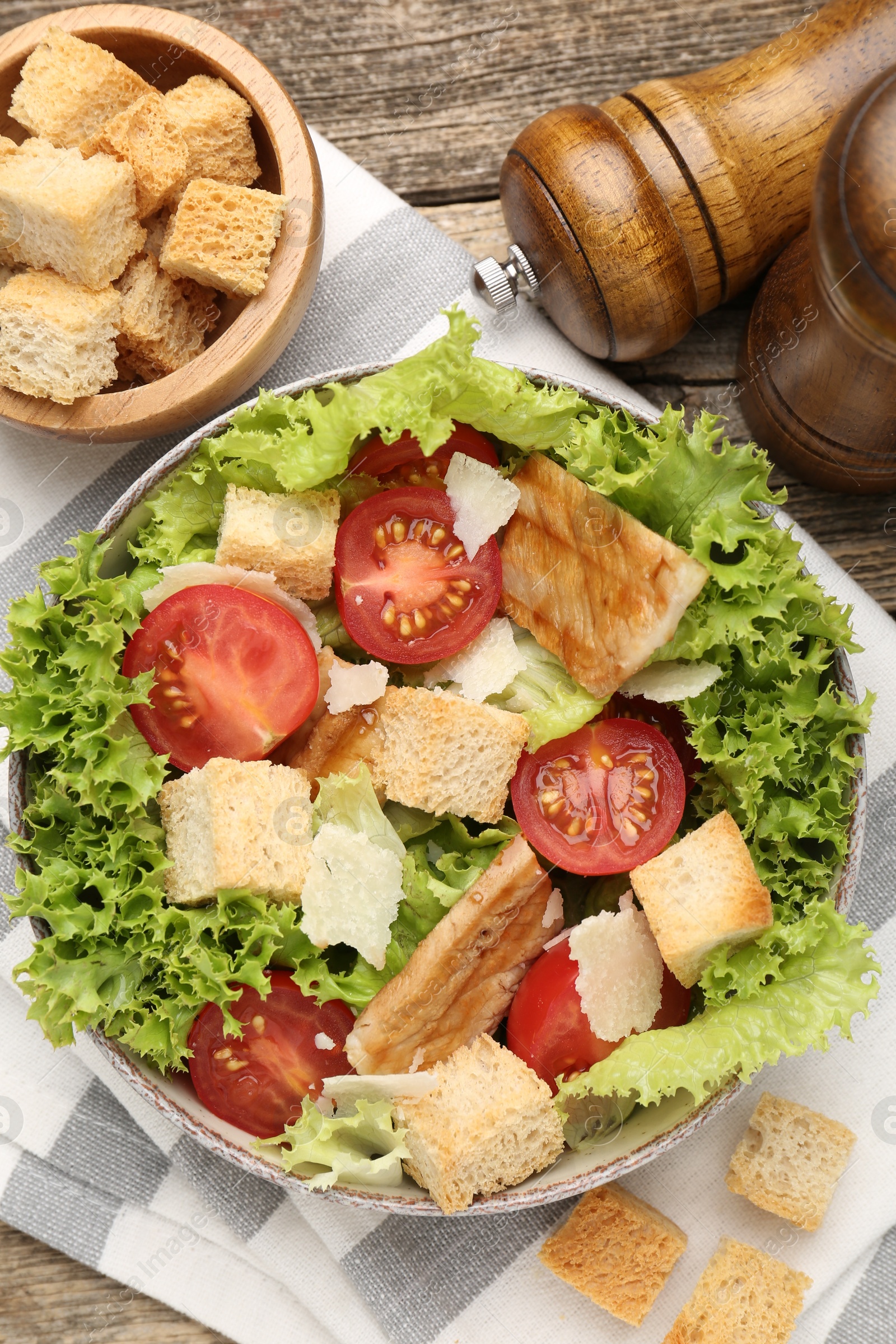Photo of Delicious salad with croutons served on wooden table, flat lay