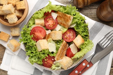 Photo of Delicious salad with croutons served on wooden table, flat lay
