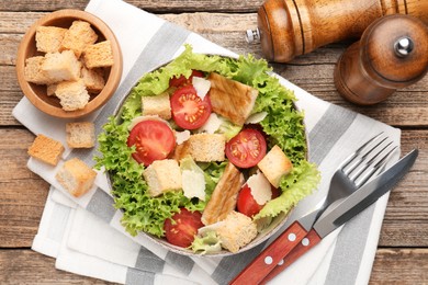 Photo of Delicious salad with croutons served on wooden table, flat lay
