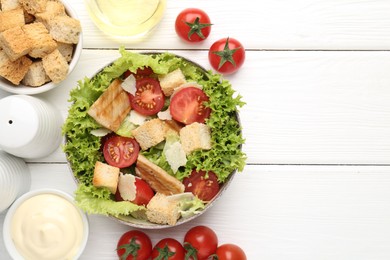 Photo of Delicious salad with croutons and ingredients on white wooden table, flat lay. Space for text