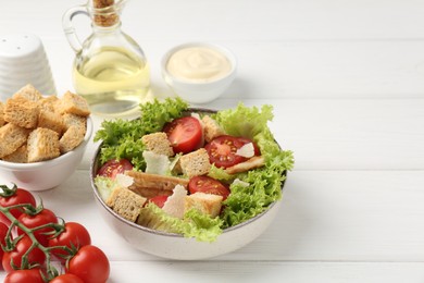Photo of Delicious salad with croutons and ingredients on white wooden table, closeup. Space for text