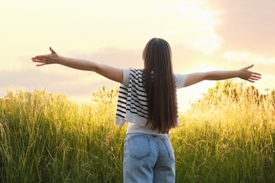 Photo of Feeling freedom. Woman enjoying time in nature, back view