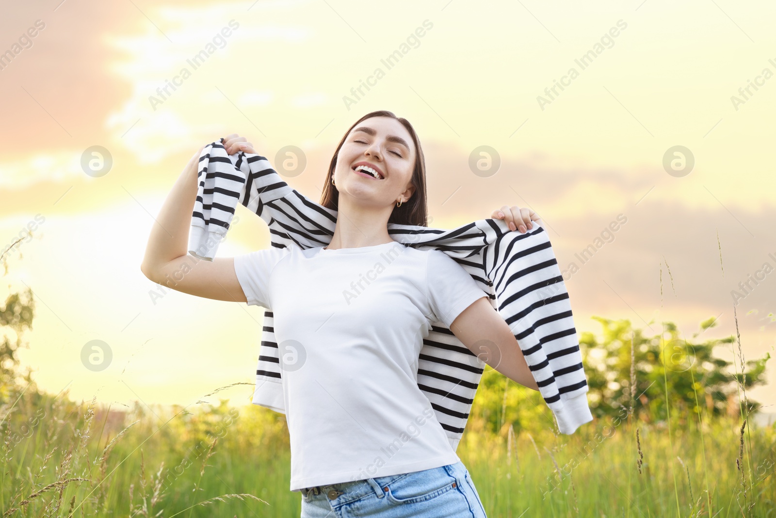 Photo of Feeling freedom. Happy young woman enjoying time in nature, low angle view