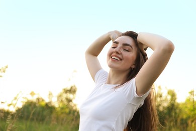 Photo of Feeling freedom. Happy young woman enjoying time in nature, low angle view