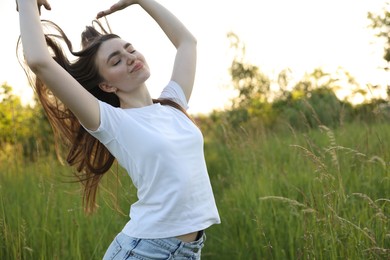 Photo of Feeling freedom. Beautiful young woman enjoying time in nature, space for text