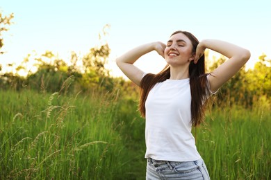 Photo of Feeling freedom. Happy young woman enjoying time in nature, space for text