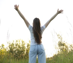 Photo of Feeling freedom. Woman enjoying time in nature, back view