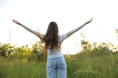 Photo of Feeling freedom. Woman enjoying time in nature, back view