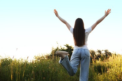 Photo of Feeling freedom. Woman enjoying time in nature, back view. Space for text