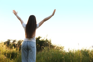Photo of Feeling freedom. Woman enjoying time in nature, back view. Space for text