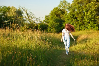 Photo of Feeling freedom. Woman running in nature, back view