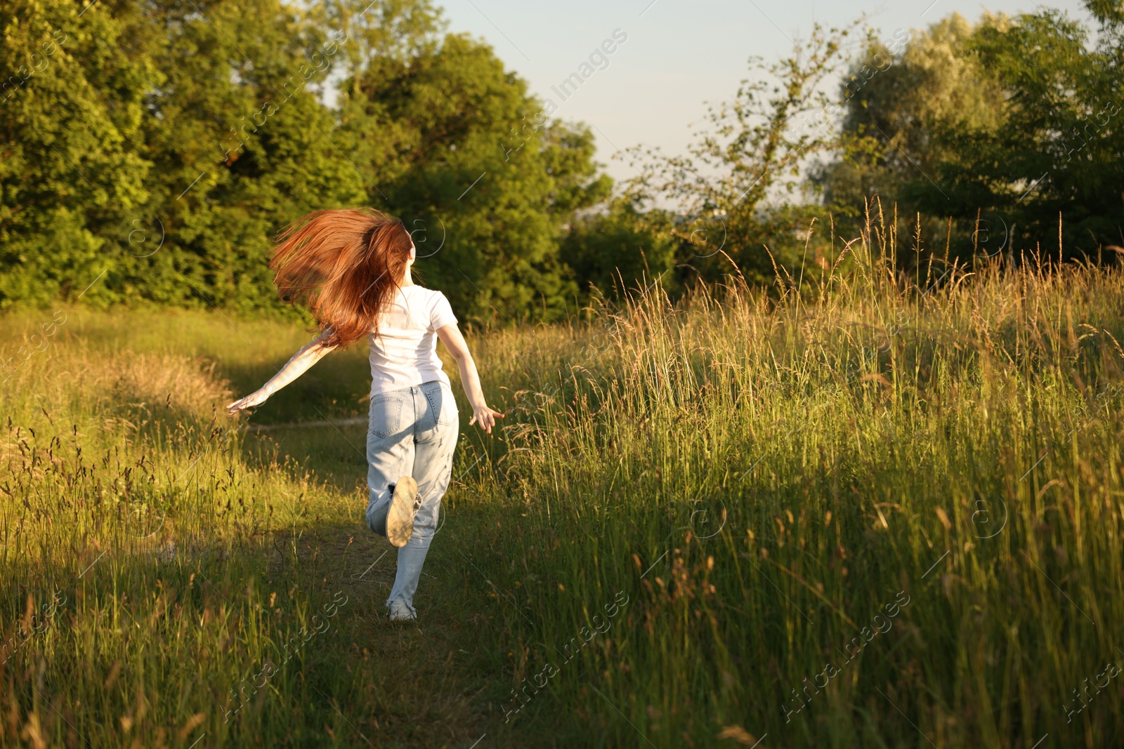 Photo of Feeling freedom. Woman running in nature, back view