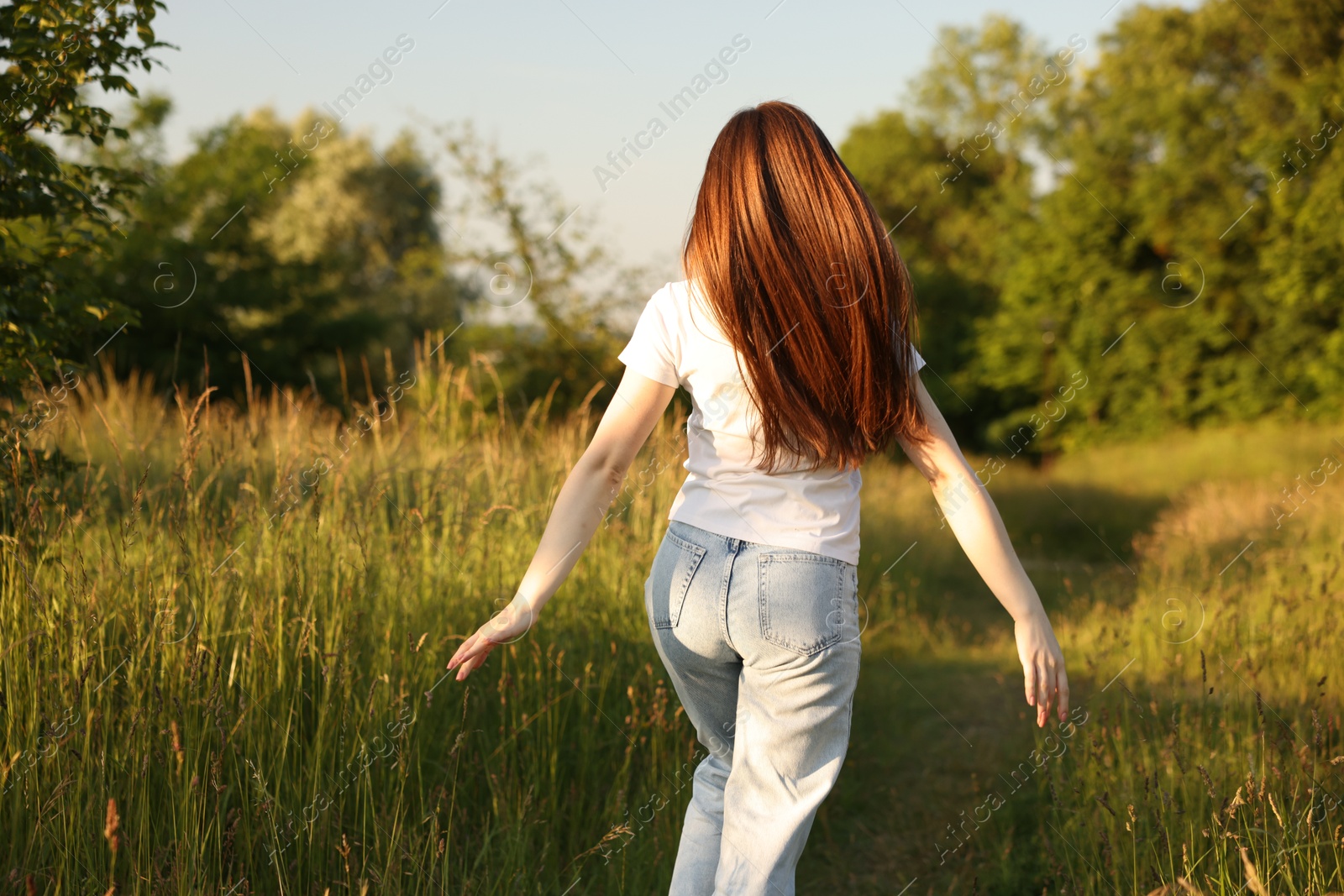 Photo of Feeling freedom. Woman running in nature, back view