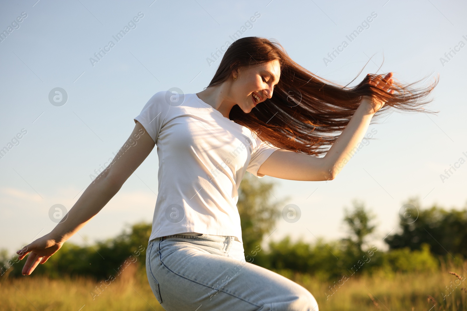 Photo of Feeling freedom. Happy young woman enjoying time in nature, low angle view