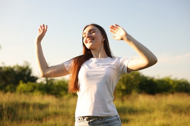 Photo of Feeling freedom. Happy young woman enjoying time in nature, low angle view
