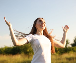 Photo of Feeling freedom. Happy young woman enjoying time in nature, low angle view