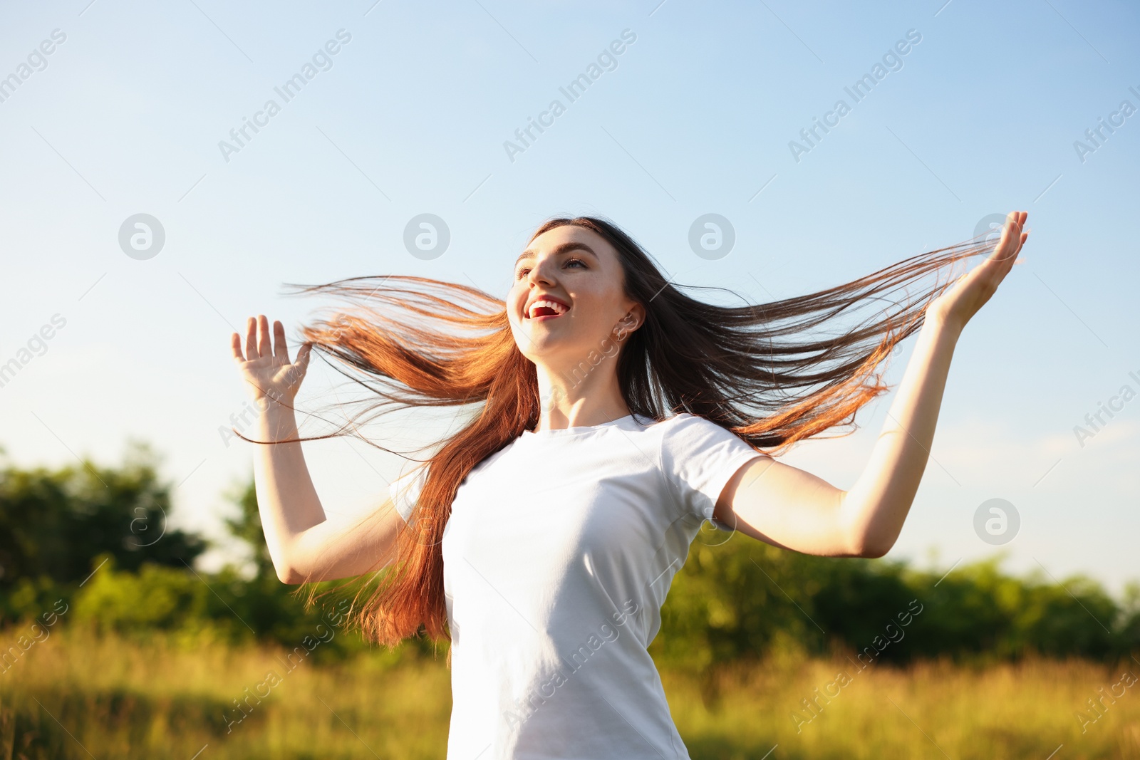 Photo of Feeling freedom. Happy young woman enjoying time in nature, low angle view