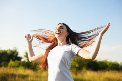 Photo of Feeling freedom. Happy young woman enjoying time in nature, low angle view
