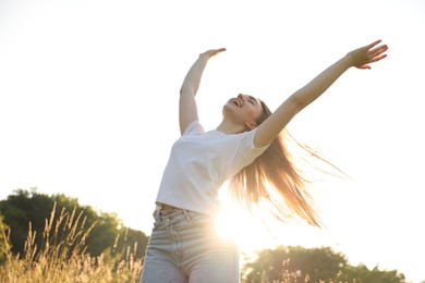 Photo of Feeling freedom. Happy young woman enjoying time in nature, low angle view