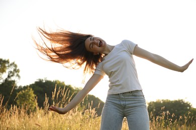 Photo of Feeling freedom. Happy young woman enjoying time in nature, low angle view