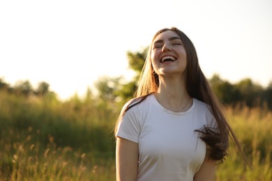 Photo of Feeling freedom. Happy young woman enjoying time in nature, space for text