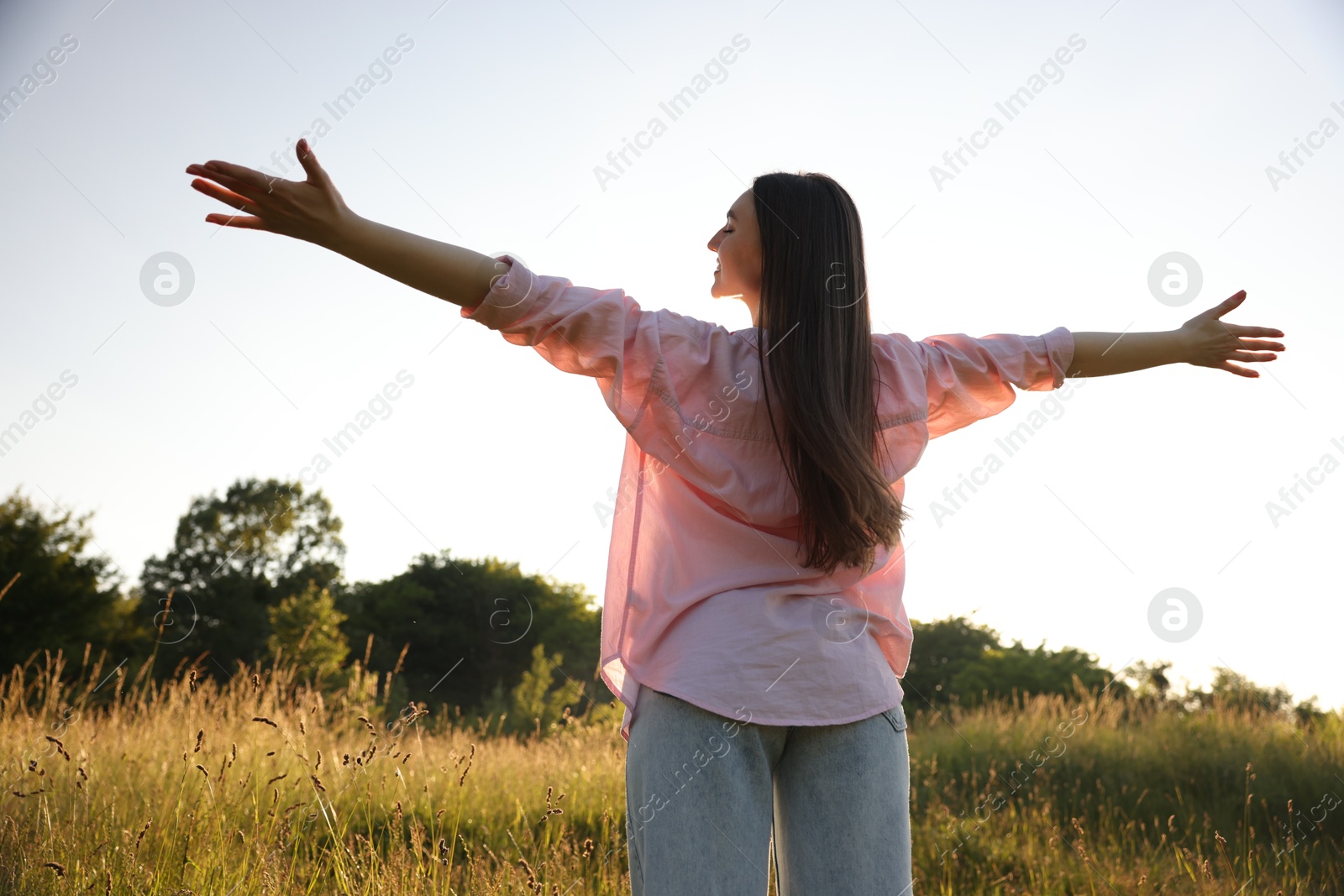 Photo of Feeling freedom. Happy young woman enjoying time in nature, low angle view
