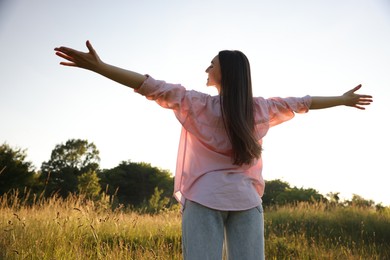 Photo of Feeling freedom. Happy young woman enjoying time in nature, low angle view